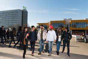 International Eine Gruppe internationaler Studierender läuft über die Mensabrücke. Im Hintergrund der Mathetower und die Mensa.